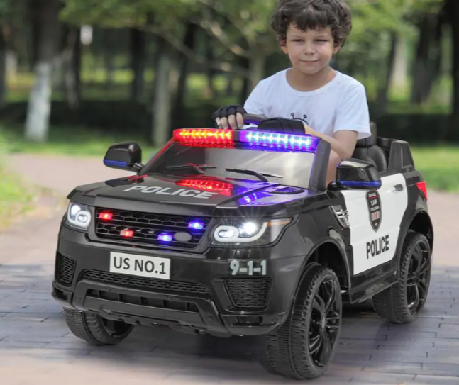 A kid is riding the ride on police car.
